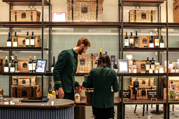 two shop attendants in harrods in front of a luxurious food display london