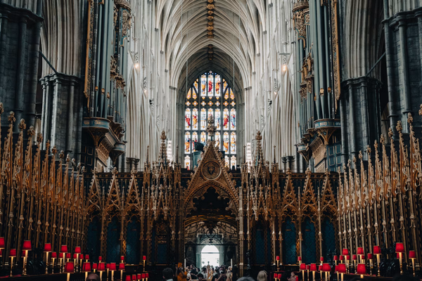 The Gothic interior of Westminster Abbey, with vaulted ceilings, ornate stonework and stained glass.